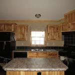 1215 - kitchen with black appliances and hickory cabinets presented by Recreational Resort Cottages and Cabins, Rockwall, Texas. Athensparkhomes.net